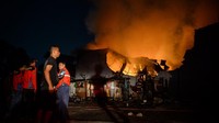 Warga melihat petugas damkar berusaha memadamkan api yang membakar pabrik konstruksi di Serpong Utara, Kota Tangerang Selatan, Banten, Senin (15/9/2025) malam. ANTARA FOTO/Putra M. Akbar