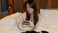 Haviza Devi Anjani bergaya di depan hadiah yang diberikan Harris Vriza. Ada kue, bunga, dan kotak merah misterius. (Foto: dok Instagram harrisvriza)