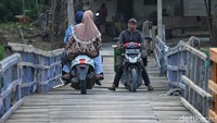 Sejumlah warga melintasi jembatan apung di Desa Sukamekar, Kabupaten Bekasi, Jawa Barat, Selasa (16/9/2025).