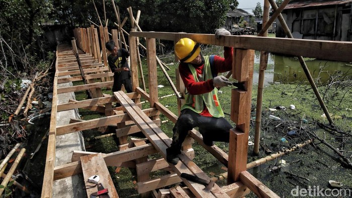 Proyek pembangunan jembatan jogging track tengah berlangsung di kawasan permukiman pesisir Marunda, Jakarta Utara, Selasa (16/9/2025). Pembangunan yang dimulai sejak Agustus lalu ini ditargetkan selesai pada Oktober mendatang.
