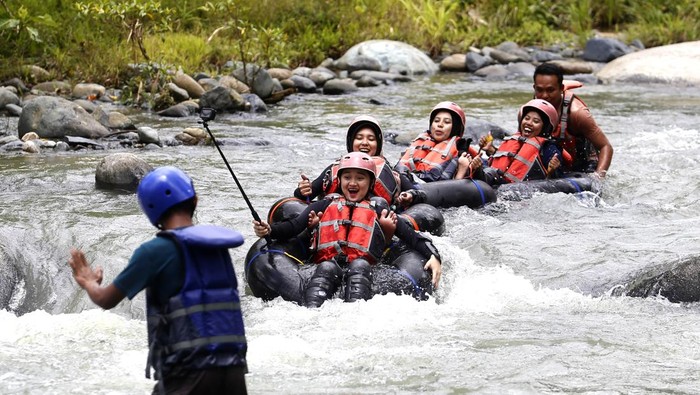 Sejumlah wisatawan meluncur bebas dengan menggunakan ban karet di objek wisata Botu Kapali River Tubing di Desa Bihe, Kabupaten Gorontalo, Gorontalo, Senin (15/9/2025). Objek wisata yang masuk dalam 50 besar Anugerah Desa Wisata (ADWI) 2024 tersebut memiliki panjang jalur 500 meter dan dikelola oleh Pemerintah Desa setempat. ANTARA FOTO/Adiwinata Solihin/nz