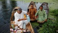 Di sela hiruk pikuk perdagangan, Mushtaq Ahmad, seorang penjual teh, tampak sibuk menuangkan cangkir-cangkir teh hangat untuk para pedagang sayur. Kehangatan teh tradisional Kashmir ini menambah semarak suasana pasar pagi. REUTERS/Sharafat Ali