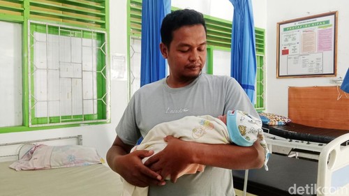 Kawil Dasan Tereng menggendong bayi yang ditemukan di musala, Selasa (16/9/2025).