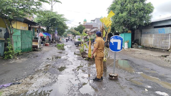 Petugas Dinas PUPR meninjau jalan rusak yang ditanami pohon pisang oleh warga Warga Dusun Bangket Dalem, Desa Kediri Selatan, Kecamatan Kediri, Lombok Barat.