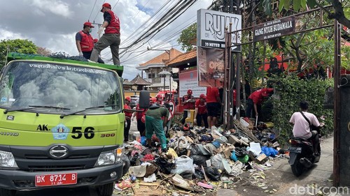 Petugas DLHK mengangkut tumpukan sampah sisa banjir di Jalan Imam Bonjol, Denpasar, Selasa (16/9/2025).