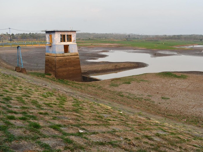 Kondisi Waduk Dawuhan yang airnya menyusut di Kabupaten Madiun, Jawa Timur, Senin (15/9/2025). Waduk yang memiliki daerah irigasi seluas 2.823 hektare sawah tersebut tinggal menyisakan sedikit air dengan sebagian besar dasar waduk mengering hingga ta