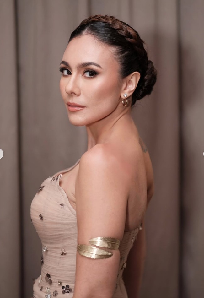 Melengkapi penampilannya, ibu 3 orang anak itu memilih riasan bernuansa nude yang kalem dan serasi dengan keseluruhan tampilannya. Contour halus, eyeshadow lembut, serta lipstik nude membuat pesona kecantikannya kian terpancar. Foto: Instagram/@wulanguritno