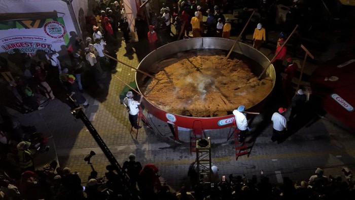Nigerian chef Hilda Baci reacts as she prepares to pour rice into a giant pot during her attempt to break the Guinness World Record for the largest pot of Jollof rice, in an open field in Lagos, Nigeria, September 12, 2025. A pot, with a capacity of over 22,000 litres, is used to prepare the popular West African dish, in a celebration of Nigerian cuisine. REUTERS/Sodiq Adelakun     TPX IMAGES OF THE DAY