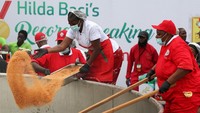 Hilda Baci menambahkan bumbu dan pasta tomat dengan cermat ke dalam panci raksasa, disaksikan ribuan penonton di Nigeria. Foto: REUTERS/Sodiq Adelakun