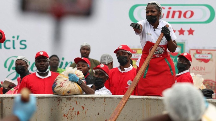 Nigerian chef Hilda Baci reacts as she prepares to pour rice into a giant pot during her attempt to break the Guinness World Record for the largest pot of Jollof rice, in an open field in Lagos, Nigeria, September 12, 2025. A pot, with a capacity of over 22,000 litres, is used to prepare the popular West African dish, in a celebration of Nigerian cuisine. REUTERS/Sodiq Adelakun     TPX IMAGES OF THE DAY