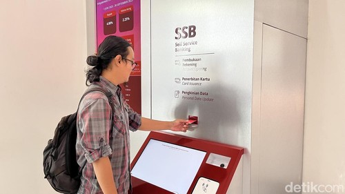 Salah seorang nasabah mencoba mesin self service CIMB Niaga di Jalan Thamrin, Denpasar, Selasa (16/9/2025).