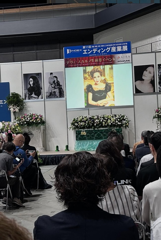 Seperti layaknya sebuah acara pemakaman, peti mati hijau Dewi tampak dihiasi dengan bunga dan diletakkan di depan, disaksikan banyak orang yang hadir. Beragam foto-foto Dewi juga tampak menghiasi. Foto: Instagram/@dewisukarnoofficial