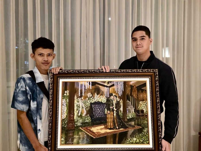 Foto Al Ghazali saat memegang hasil lukisan suasana pernikahannya, hasil karya Azmi. Foto Azmi sebagai pemilik jasa live wedding painting @azmi_sketcher.