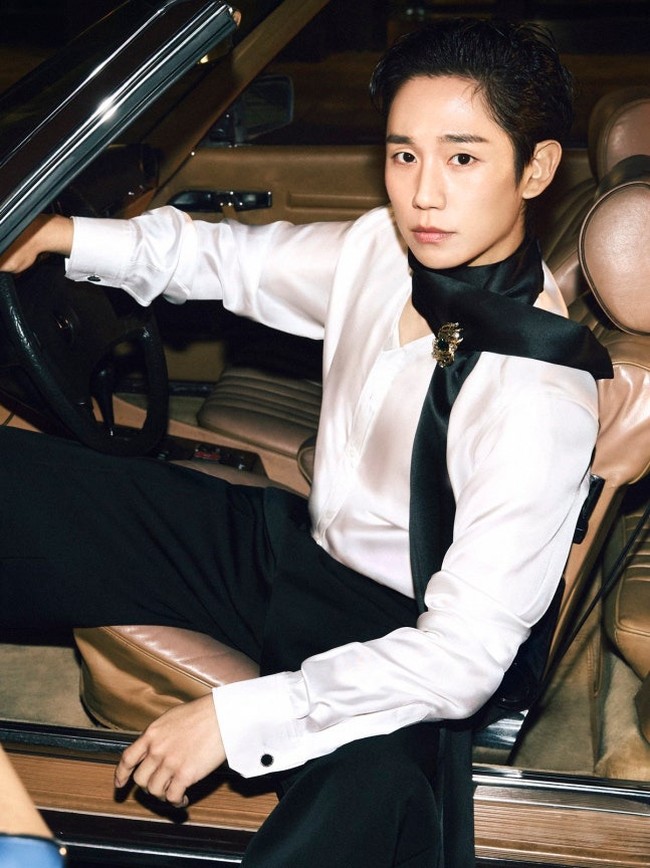 Dalam foto terbaru yang dirilis Dolce & Gabbana, Jung Hae In berpose di atas mobil klasik dengan rambut yang disisir rapi ke belakang. Berbalut paduan kemeja sutra dan syal yang melingkar di lehernya, menonjolkan gaya flamboyan. Foto: dok. Dolce & Gabbana