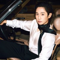 Dalam foto terbaru yang dirilis Dolce & Gabbana, Jung Hae In berpose di atas mobil klasik dengan rambut yang disisir rapi ke belakang. Berbalut paduan kemeja sutra dan syal yang melingkar di lehernya, menonjolkan gaya flamboyan. Foto: dok. Dolce & Gabbana