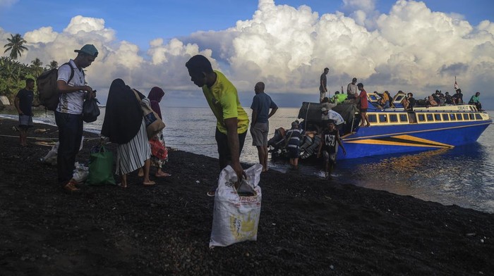 Seorang penumpang tujuan Ternate membawa barang bawanya bersiap menaiki speedboat (kapal cepat) saat sandar di tepi pantai di Desa Waigitang, Pulau Makian, Halmahera Selatan, Maluku Utara, Rabu (17/9/2025). Menurut warga setempat, daerah Makian yang berada di pulau terluar di Kabupaten Halmahera Selatan itu belum memiliki infrastruktur dermaga yang memadai sehingga warga yang akan bepergian harus melalui pantai tanpa dermaga yang disediakan. ANTARA FOTO/Andri Saputra
