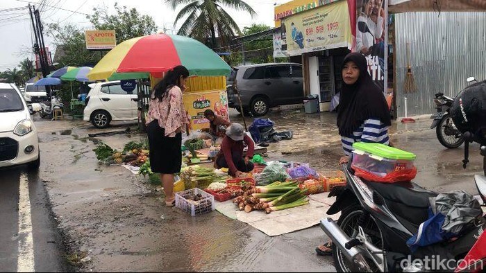 Pedagang di Palangka Raya berjualan lebih siang karena hujan.