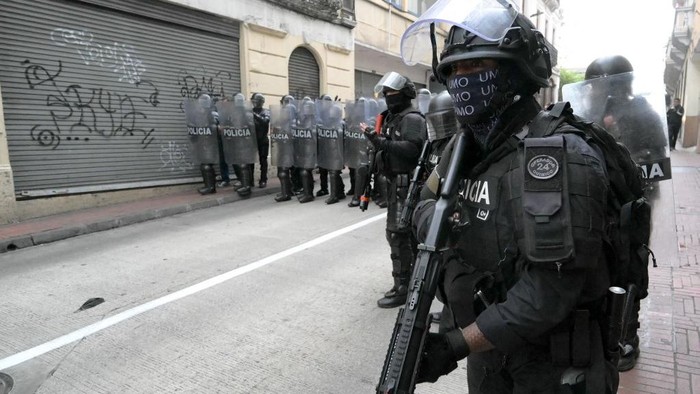 Ecuadorian riot police officers stand guard during a protest against President Daniel Noboas cuts and the elimination of diesel subsidy within a state of emergency declared by the government in Quito on September 16, 2025. (Photo by Rodrigo BUENDIA / AFP)