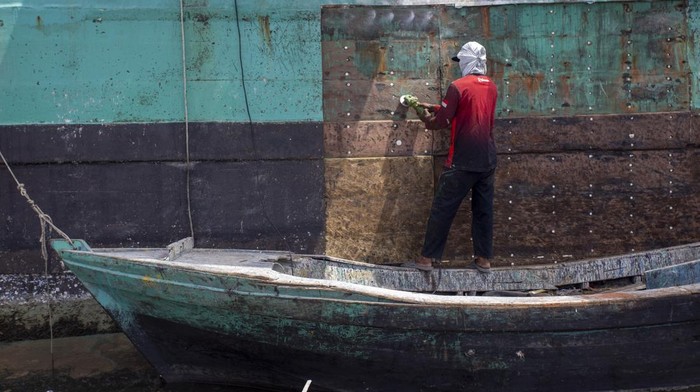 Pekerja memperbaiki lambung kapal nelayan di dermaga Karangsong, Indramayu, Jawa Barat, Rabu (17/9/2025). Pemerintah menyiapkan anggaran sebesar Rp48 triliun untuk program modernisasi 1000 kapal nelayan sebagai bagian paket kebijakan stimulus ekonomi yang diperkirakan akan menyerap 200.000 tenaga kerja baru. ANTARA FOTO/Dedhez Anggaara