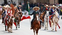Warga yang memadati jalan-jalan utama Mexico City tampak antusias menyaksikan parade. Tepuk tangan dan sorakan meriah mengiringi langkah para peserta, sementara bendera-bendera Meksiko berkibar di sepanjang rute parade, mempertegas semangat nasionalisme di momen bersejarah ini. REUTERS/Raquel Cunha