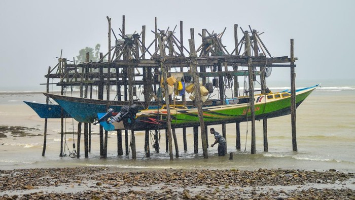 Nelayan mengikat perahunya dengan cara digantung di Desa Soligi, Pulau Obi, Halmahera Selatan, Maluku Utara, Rabu (17/9/2025). Nelayan Desa Soligi memiliki tradisi menggantung perahu mereka setelah melaut agar memudahkan saat digunakan kembali dan terhindar dari hempasan ombak. ANTARA FOTO/Iggoy el Fitra/rwa.
