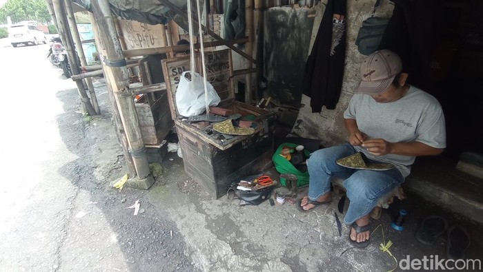 Tukang sol di kawasan Simpang Tiga Sukawarni Tasikmalaya tengah tekun bekerja.