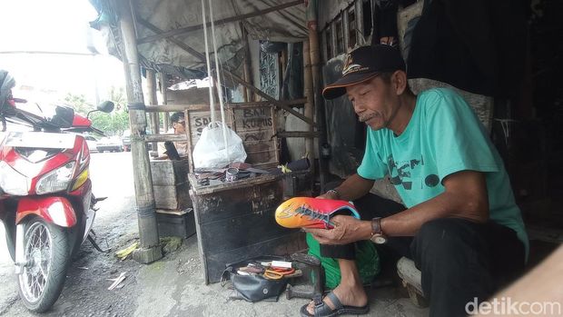 Tukang sol di kawasan Simpang Tiga Sukawarni Tasikmalaya tengah tekun bekerja.