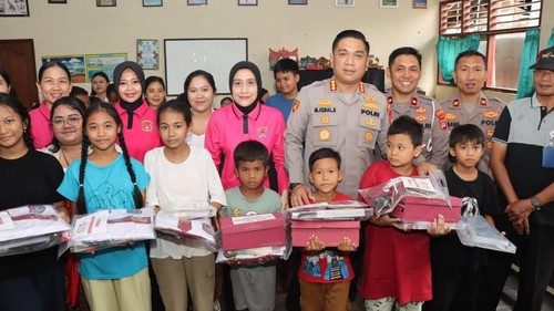 Kapolresta Denpasar Kombes M Iqbal Simatupang memberikan bantuan kepada siswa SD yang terdampak banjir