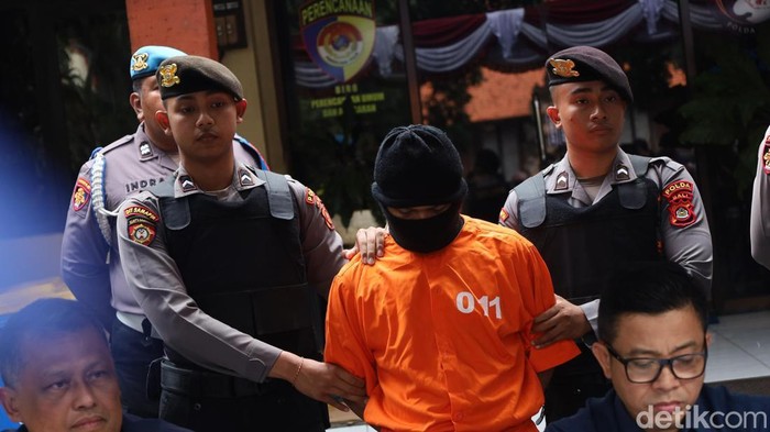 Kurir narkoba berinisial SJ dihadirkan saat konferensi pers pengungkapan kasus peredaran sabu-sabu dan ekstasi di Mapolda Bali, Kamis (18/9/2025). (Foto: Aryo Mahendro/detikBali)
