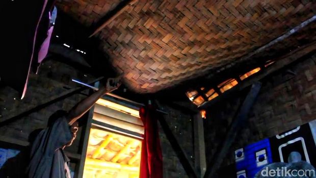 Potret luar rumah keluarga Ana di Sukabumi, dengan dinding bambu lapuk dan atap genteng yang sudah ditambal seadanya.
