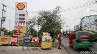 Seorang karyawan menjajakan makanan ringan dan minuman kemasan yang dijual di depan SPBU. Upaya ini dilakukan agar ada pemasukan di tengah mandeknya penjualan BBM.