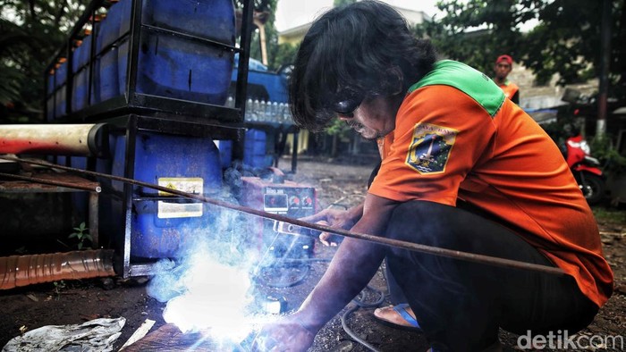 Petugas UPS Badan Air Cipayung merakit perahu unik berbentuk oplet legendaris Si Doel dari botol plastik bekas di kawasan Setu, Jakarta Timur, Kamis (18/9/2025).