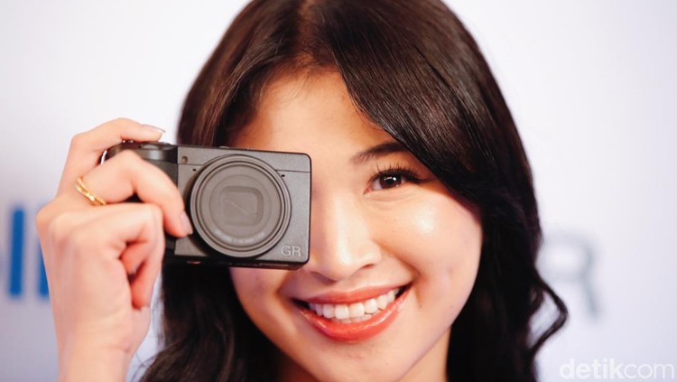 Mantan Kapten JKT48 Shani Indira menggenggam kamera Ricoh GR IV terbaru di Jakarta, Kamis, (18/9/2025).