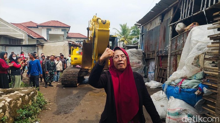 Seorang Warga Mengadang Akat Berat yang Hendak Tertibkan Bangunan Liar