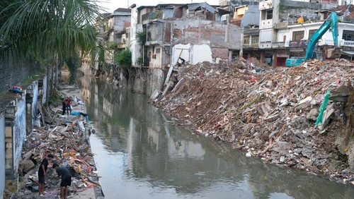 Warga membersihkan puing-puing bangunan pascabencana banjir di Sungai Badung, Denpasar, Bali, Rabu (17/9/2025). Pemerintah Kota Denpasar secara resmi telah menurunkan status Tanggap Darurat Bencana menjadi status Transisi Darurat ke Pemulihan selama tiga bulan mulai 17 September hingga 17 Desember 2025. ANTARA FOTO/Nyoman Hendra Wibowo/aww.