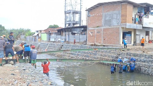 Suasana pemasangan jembatan semi permanen di Lingkungan Karang Kemong, Cakranegara, Kota Mataram, Kamis (18/9/2025). (Nathea Citra/detikBali)