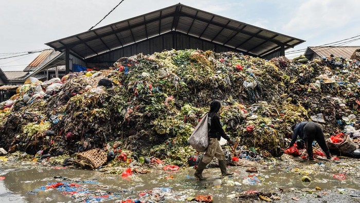 Pemulung melintasi tumpukan sampah Pasar Induk Caringin, Bandung, Jawa Barat, Jumat (19/9/2025). Setelah sempat dibersihkan pada Mei 2025 lalu, tumpukan sampah di Pasar Induk Caringin kembali menggunung dan dikeluhkan oleh pengunjung karena dinilai mengganggu kenyamanan serta berpotensi menimbulkan berbagai macam penyakit. ANTARA FOTO/Raisan Al Farisi/foc.