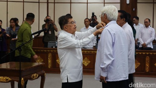 JK menyematkan tanda jabatan ke salah satu pengurus PMI Bali di kantor gubernur Bali, Jumat (19/9/2025).