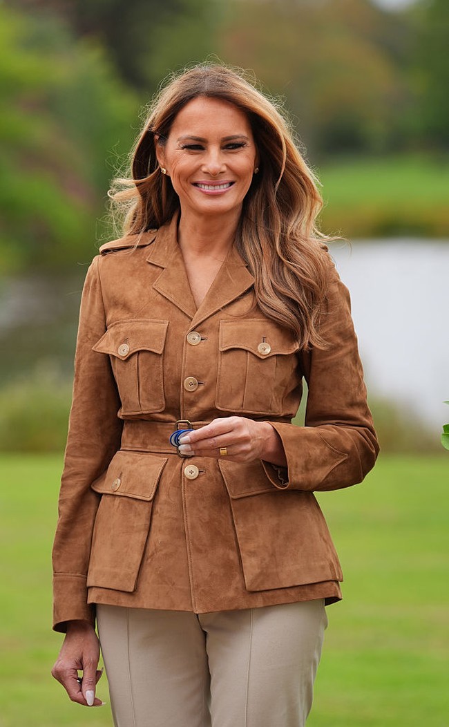 Melania memilih gaya safari chic dengan jaket suede caramel dari Ralph Lauren. Ia memadukannya bersama celana cropped dari Loro Piana dan flat shoes Roger Vivier. Foto: Getty Images/WPA Pool
