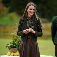 Seolah berada di frekuensi yang sama, Kate dan Melania kompak memilih jaket suede dengan nuansa warna musim gugur. Sang Putri Wales tampil dalam balutan cropped military jacket berwarna hijau zaitun dari Me + Em. Ia memadukannya dengan rok panjang tweed Evilyn Birdseye dari Ralph Lauren, dilengkapi belt kulit bertekstur croc dan syal sutra hijau. Foto: Getty Images/WPA Pool