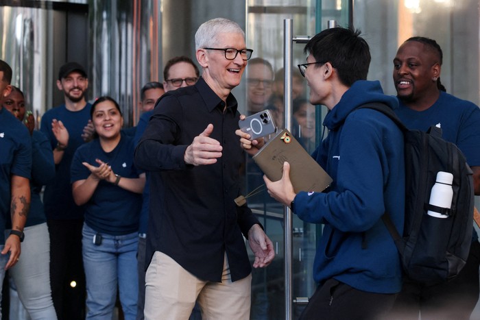Apple CEO Tim Cook greets a customer, as the iPhone 17 series goes on sale, at the Apple Store in New York City, U.S., September 19, 2025. REUTERS/Shannon Stapleton