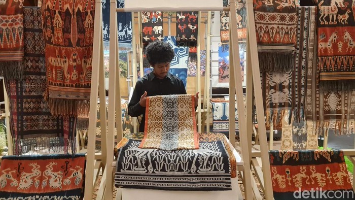 Pengunjung mengamati deretan kain tenun ikat khas NTT yang dipamerkan di Menara Astra, Jakarta, Jumat (19/9/2025).