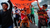 Aktivis mengenakan kostum dinosaurus saat aksi, simbol protes terhadap proyek pembangunan yang merusak ruang hidup masyarakat. Aksi Draw The Line ini mendesak pemerintah dan pembuat kebijakan untuk membuat kebijakan dari partisipasi masyarakat bukan elit, melindungi rakyat bukan oligarki, menerapkan pajak bagi yang kaya dan merusak serta transisi energi bersih.
