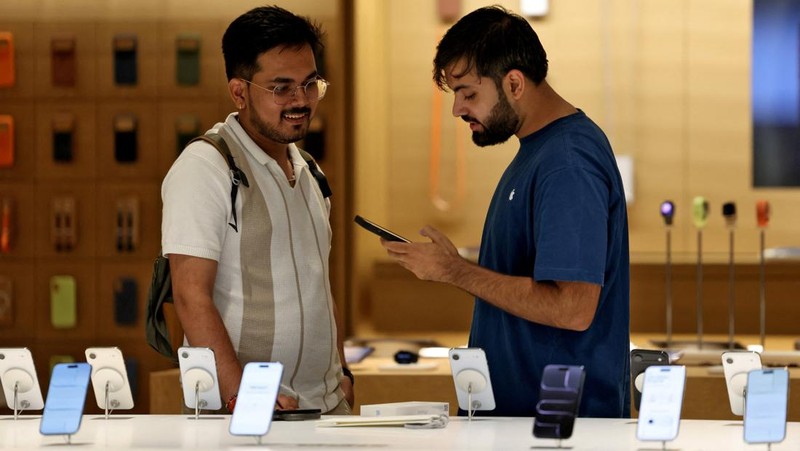 A customer compares his old iPhone with the newly launched iPhone 17 pro max at an Apple retail store in Delhi, India, September 19, 2025. REUTERS/Bhawika Chhabra