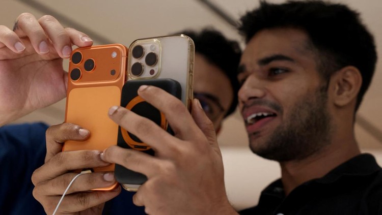 Warga India Antre Panjang Demi Beli iPhone 17 A customer compares his old iPhone with the newly launched iPhone 17 pro max at an Apple retail store in Delhi, India, September 19, 2025. REUTERS/Bhawika Chhabra