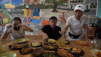Ayah Ojak sebagai tuan rumah memastikan Irfan Hakim makan dengan lahap. Ia juga mengadukkan gula pasir di es jeruk milik artis pencinta hewan tersebut. Foto: YouTube deHakmis Story