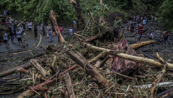 Sejumlah warga melihat material longsor yang menutupi jalan lingkar Ternate di Maluku Utara, Sabtu (20/9/2025). Curah hujan dengan intensitas tinggi pada Jumat (19/9) sore mengakibatkan jalan nasional yang menghubungkan Kelurahan Taduma dan Togafo itu tertutup material longsor dampak banjir dari Gunung Gamalama yang melewati jalur kali mati sehingga jalan lingkar pulau Ternate tidak bisa dilewati untuk sementara. ANTARA FOTO/Andri Saputra/rwa.