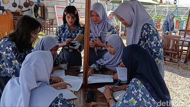 Para siswa belajar di Perpusatakaan Luar Ruangan di SMK 8 Palembang.