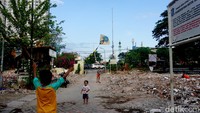 Sejumlah anak-anak di Kampung Gayungan atau Kampung Tengah Ahmad Yani sedang bermain layang-layang diantara bangunan rumah yang telah dibongkar.