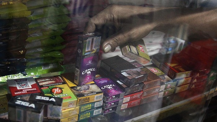 Tarif Cukai Rokok TInggi Pedagang kaki lima (PKL) menunggu pembeli dan menunjukkan pita cukai yang menempel di bungkus rokok di Jakarta, Minggu (20/9/2025). Menteri Keuangan (Menkeu) Purbaya Yudhi Sadewa menyatakan kaget atas tarif cukai rokok yang sangat tinggi mencapai 57%.